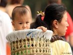 Em um passeio no zoológico, a mãe carrega o filho dentro de um balaio nas costas. Costumes chineses. </br></br> Palavras-chaves: Cultura. China. Hábitos. 